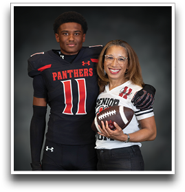 A person in a football uniform with the word Panthers and number 11 stands next to another person wearing glasses and a senior football jersey holding a football, both smiling against a dark background. Description generated by AI