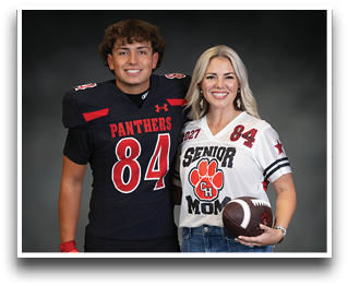 Two people smiling and standing side by side, one wearing a black football uniform with the number 84 and the other wearing a white “Senior Mom" jersey holding a football. Description generated by AI