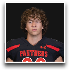 Person with curly hair wearing a black sports jersey with red accents and the word “PANTHERS" across the chest. Description generated by AI