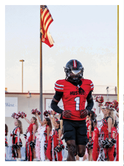 Two football players wearing black jerseys and holding hands. Description generated by AI