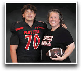A person wearing a football uniform with the number 70 stands next to another person holding a football and wearing a shirt that says “Panther Football," both smiling against a dark background. Description generated by AI
