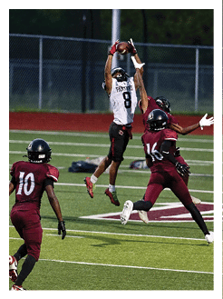 Two football players wearing black jerseys and holding hands. Description generated by AI