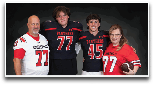 Four people wearing football jerseys with the numbers 77 and 45 pose together against a dark background, with one person holding a football. Description generated by AI