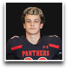 Person with curly hair wearing a black and red football jersey with the word Panthers on the front. Description generated by AI