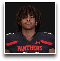 Person with medium-length curly hair wearing a black football jersey with red accents and the word “PANTHERS" on the front. Description generated by AI