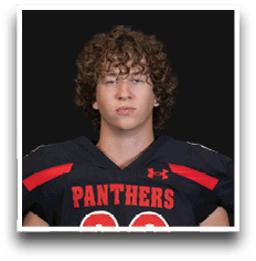 Person with curly hair wearing a black sports jersey with red accents and the word “PANTHERS" across the chest. Description generated by AI