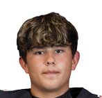 A person wearing a black football jersey with red accents and the word Panthers along with the number 5 on the front stands facing forward with one arm behind their back. Description generated by AI