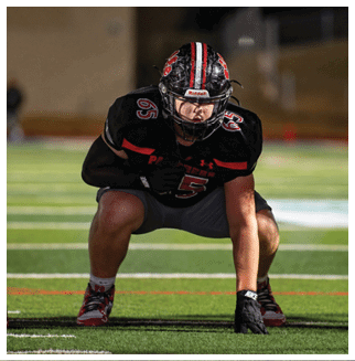 A football player wearing a blue and red jersey. Description generated by AI