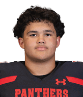 A person with short curly hair wearing a black football jersey with red accents and the word Panthers on the front is looking straight ahead. Description generated by AI