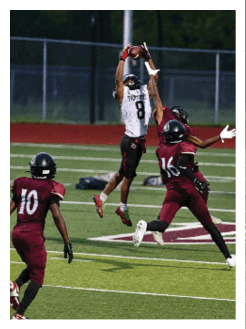 Two football players wearing black jerseys and holding hands. Description generated by AI