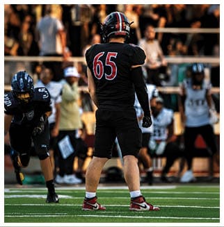 A football player wearing a blue and red jersey. Description generated by AI
