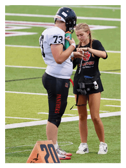 Two football players wearing black jerseys and holding hands. Description generated by AI