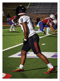 Two football players wearing black jerseys and holding hands. Description generated by AI