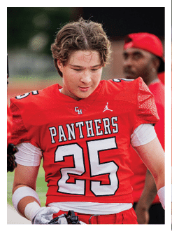 Two football players wearing black jerseys and holding hands. Description generated by AI