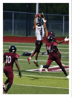 Two football players wearing black jerseys and holding hands. Description generated by AI