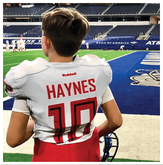 A football player wearing a blue and red jersey. Description generated by AI