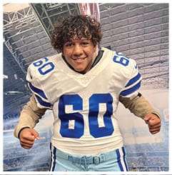 A football player wearing a blue and red jersey. Description generated by AI