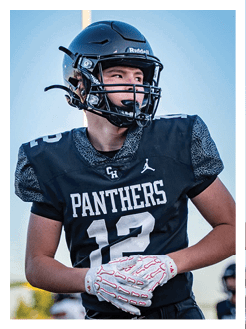 Two football players wearing black jerseys and holding hands. Description generated by AI