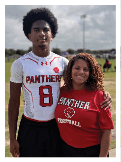 Two football players wearing black jerseys and holding hands. Description generated by AI