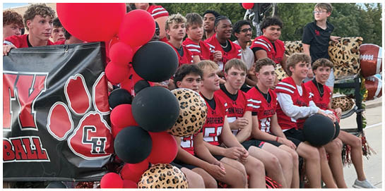 A cluster of red and black balloons is next to a black and red banner featuring stylized red hand shapes outlined in white. Description generated by AI