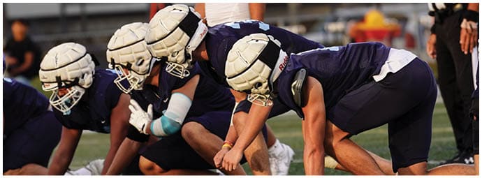 A football player wearing a blue and white uniform. Description generated by AI