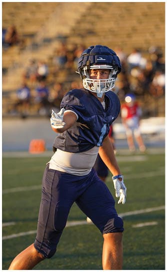 A football player catching a ball. Description generated by AI