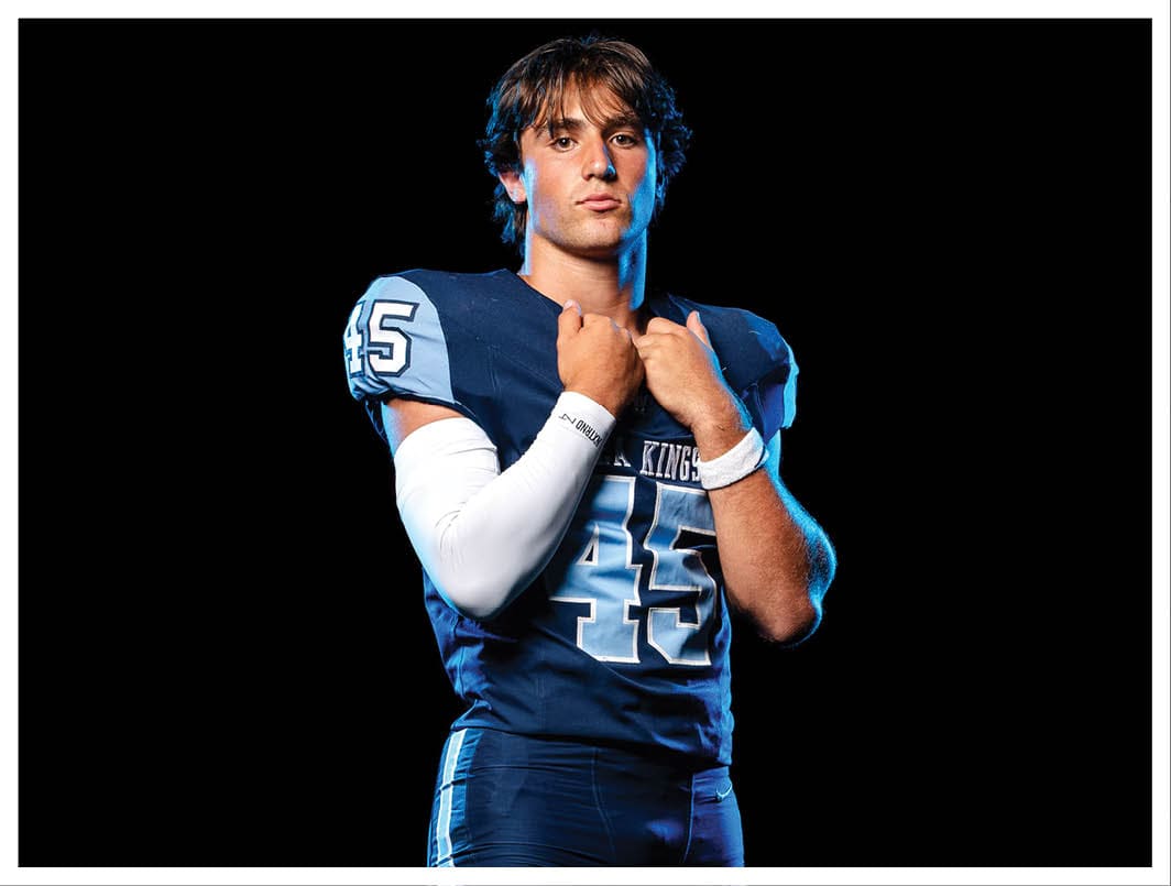 A football player wearing a blue and red jersey. Description generated by AI