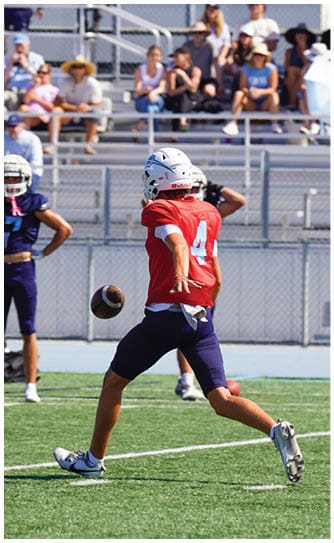 A football player catching a ball. Description generated by AI