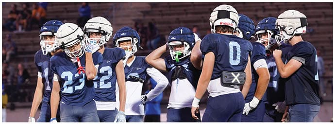 A football player wearing a blue and white uniform. Description generated by AI
