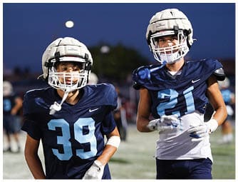 A group of football players on a field. Description generated by AI