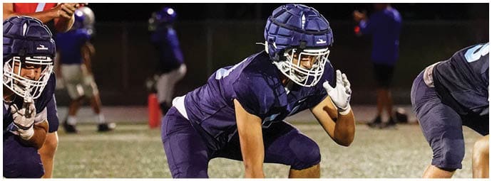 A football player wearing a blue and white uniform. Description generated by AI