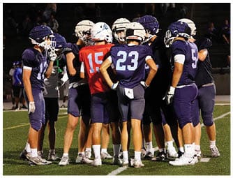 A group of football players on a field. Description generated by AI