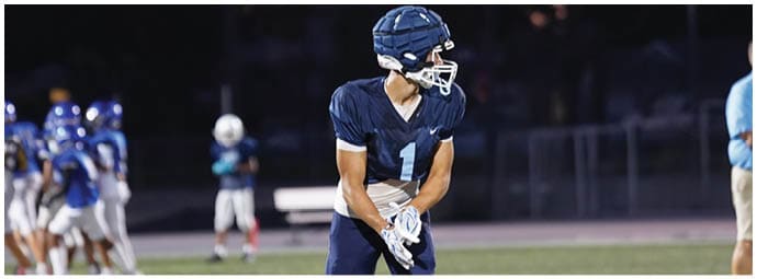 A football player wearing a blue and white uniform. Description generated by AI