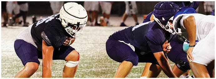 A football player wearing a blue and white uniform. Description generated by AI