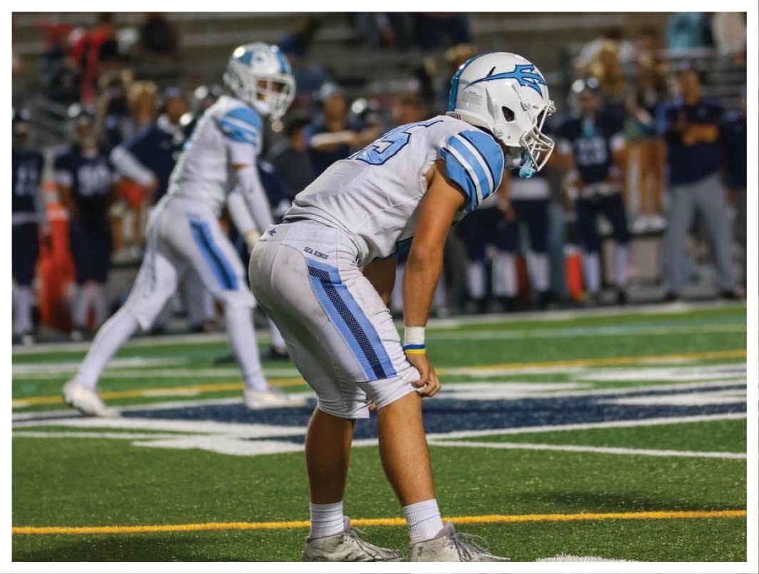 A football player wearing a blue and red jersey. Description generated by AI