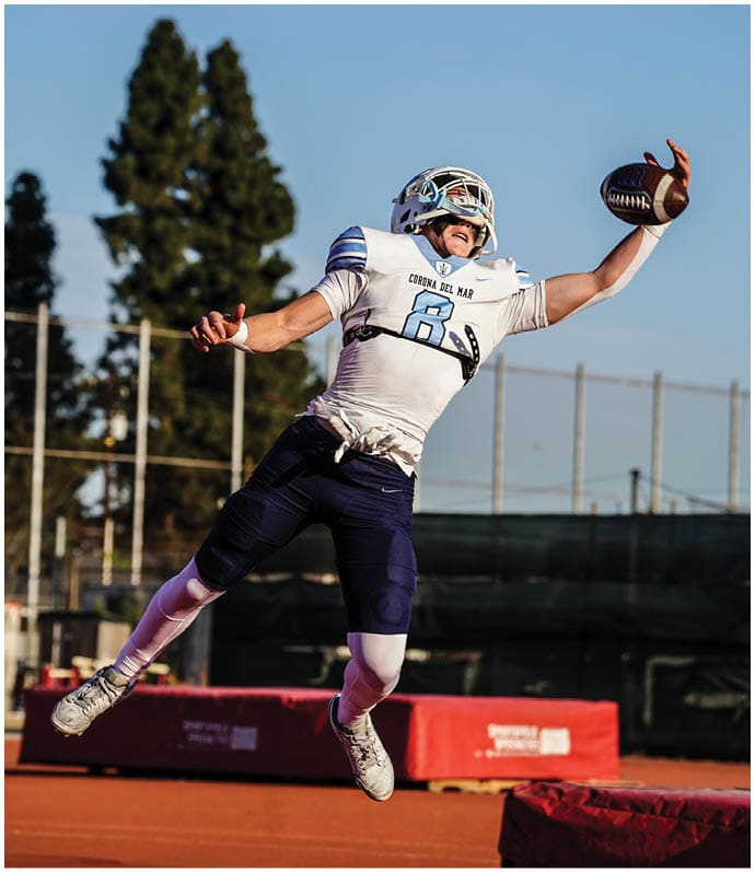 Three football players in blue and white uniforms running on a field. Description generated by AI