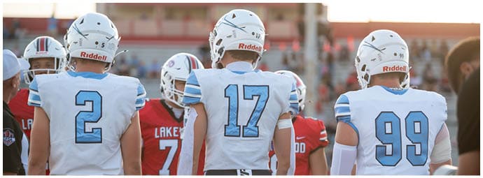 A football player wearing a blue and white uniform. Description generated by AI
