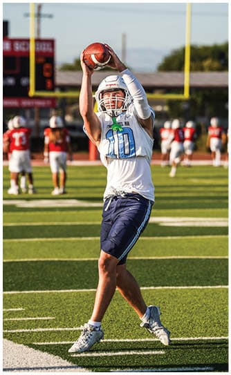 A football player catching a ball. Description generated by AI