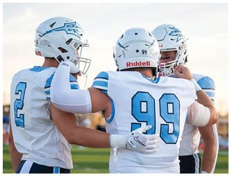 A group of football players on a field. Description generated by AI