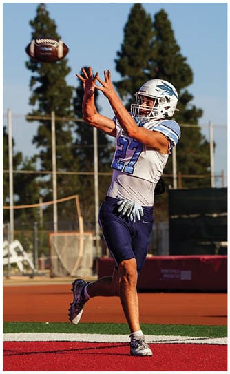 A football player catching a ball. Description generated by AI