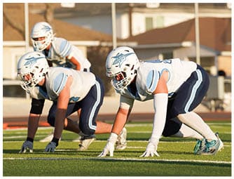 A group of football players on a field. Description generated by AI