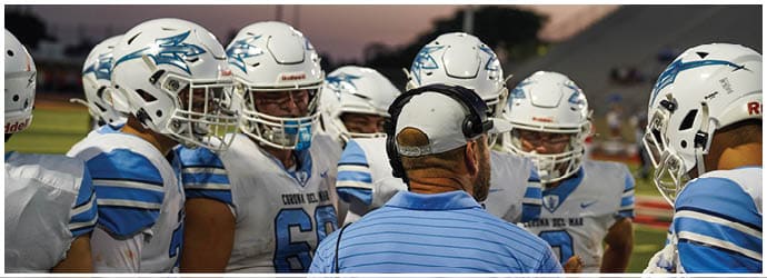 A group of football players on a field. Description generated by AI