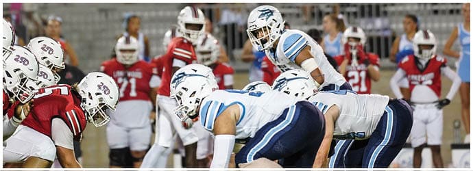 A group of football players on a field. Description generated by AI