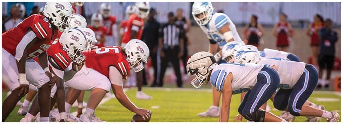 A group of football players on a field. Description generated by AI