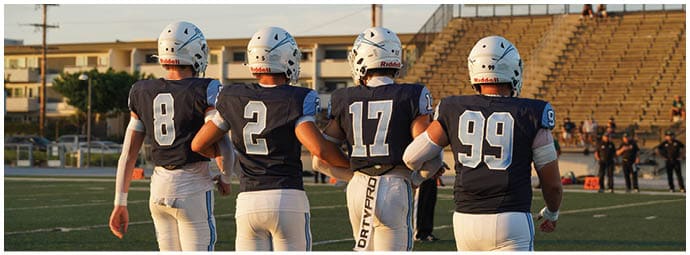 A football player wearing a blue and white uniform. Description generated by AI