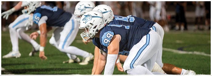 A group of football players on a field. Description generated by AI