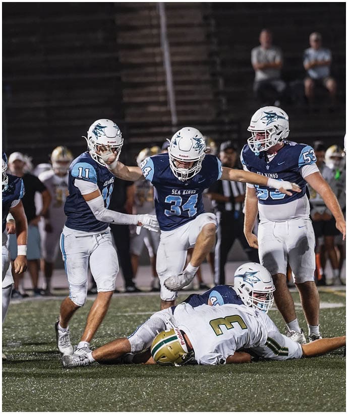 A group of football players wearing black and white uniforms. Description generated by AI