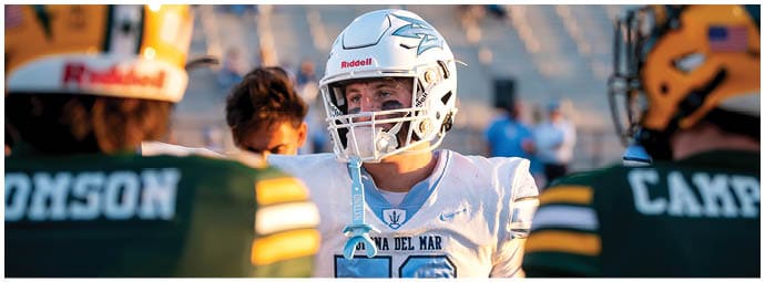 A football player wearing a blue and white uniform. Description generated by AI