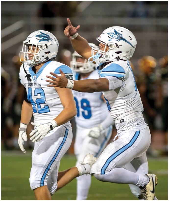 A group of football players wearing black and white uniforms. Description generated by AI