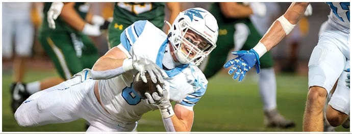 A football player is sliding on the ground. Description generated by AI